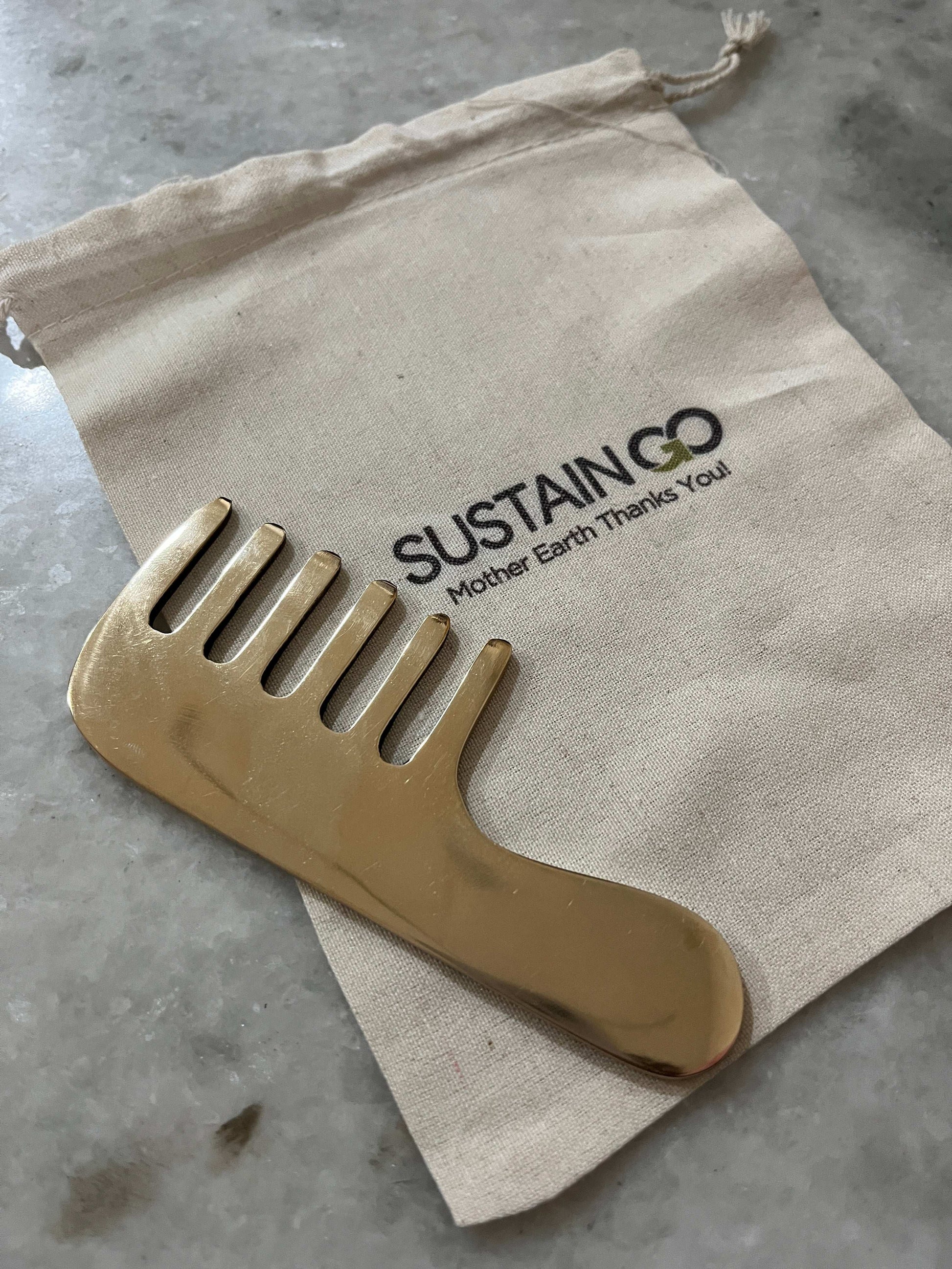 Pure kansa metal hair kanga comb placed on SustainGo eco-friendly pouch for kansa massage